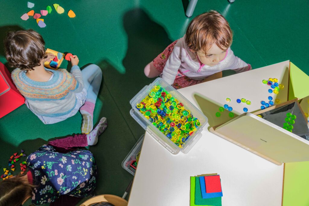 Kinder arbeiten mit Muggelsteinen an mathematischen Basiskompetenzen.